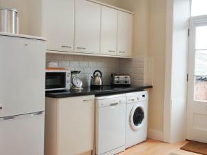 a kitchen with a washing machine and a microwave at Stunning apartment in the centre of Corbridge in Corbridge