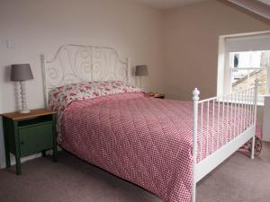 a bedroom with a bed with a red and white bedspread at Stunning apartment in the centre of Corbridge in Corbridge