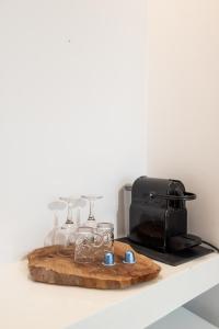 a shelf with a tray of glasses and a toaster at Anamnisi Mykonos in Mikonos