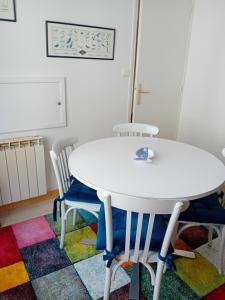 una mesa blanca y sillas en una habitación en La Goélette Beau duplex A 150 m du centre ville et 400m de la plage de l'écluse, en Dinard