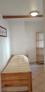 1 dormitorio con 1 cama en la esquina de una habitación en Métropole, en Embrun