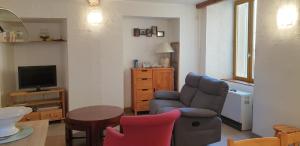 a living room with a chair and a television at Métropole in Embrun