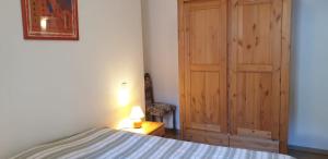 1 dormitorio con 1 cama y puerta de madera en Métropole, en Embrun