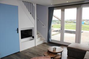 a living room with a couch and a tv at Huis over de dijk in De Kwakel