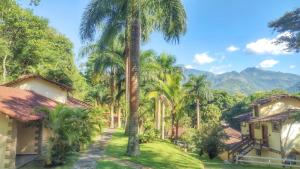 a resort with palm trees and mountains in the background at Pousada J Country in Sana