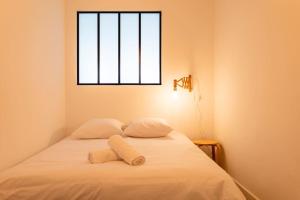 een bed met 2 kussens en een raam in een kamer bij Vieux Port - Le Quai in Marseille