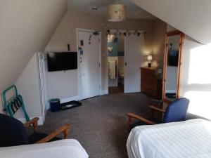 a room with a bed and a tv and a bedroom at Treventon Guest House in Penzance