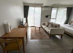 a living room with a couch and a table at The Deck Condominium by Lofty in Patong Beach