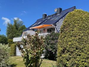 a house with a solar roof and some bushes at An de Bäk Bornstübchen in Born