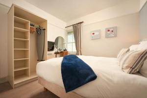 a bedroom with a white bed with a blue blanket on it at Rashleigh Arms in St Austell