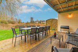 a patio with a table and chairs on a deck at Firecrest in Somerford Keynes