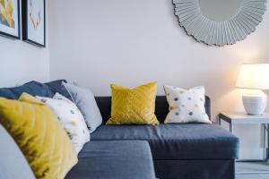 a blue couch with yellow and white pillows at OPP Liverpool - Perfect for contractors and travellers, BIG SAVINGS booking 4 nights or more! in Liverpool