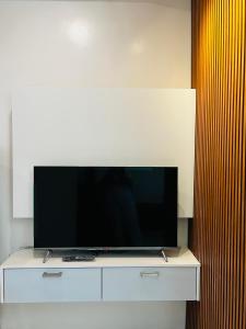 uma televisão de ecrã plano em cima de uma cómoda branca em KENNA'S NOOK em Butuan