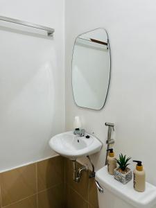 La salle de bains est pourvue d'un lavabo et d'un miroir sur les toilettes. dans l'établissement KENNA'S NOOK, à Butuan