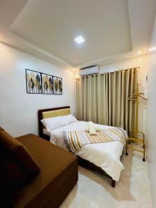 a bedroom with two beds and a couch at KENNA'S NOOK in Butuan