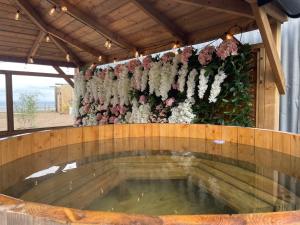 a large pool of water with flowers on a wall at Top Pen Y Parc Farm Glamping in Holywell