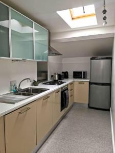a kitchen with a sink and a refrigerator at Stylish apartment in the centre of Hebden Bridge. in Hebden Bridge