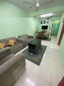 - un salon avec un canapé et une table dans l'établissement Aziz homestay, à Gemencheh