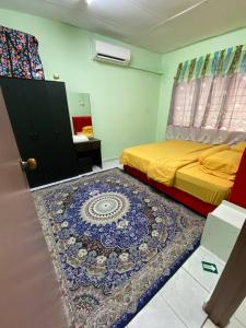 - une chambre avec un lit et un tapis au sol dans l'établissement Aziz homestay, à Gemencheh