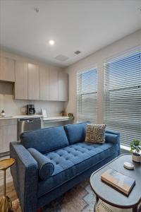 a living room with a blue couch and a table at CozySuites Modern SDO, Lawrenceville in Pittsburgh