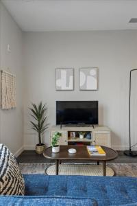 a living room with a coffee table and a tv at CozySuites Modern SDO, Lawrenceville in Pittsburgh