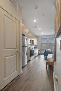 an open door to a kitchen with a refrigerator at CozySuites Modern SDO, Lawrenceville in Pittsburgh
