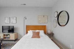 ピッツバーグにあるCozySuites Stylish SDO, Lawrencevilleの白いベッドと鏡のある寝室 +26枚の写真