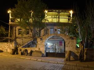 budynek z łukiem przed nim w nocy w obiekcie Philosophy Hotel w mieście Uçhisar