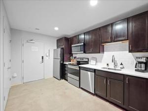 uma grande cozinha com armários e electrodomésticos de madeira em CozySuites Roomy 1BR, Downtown Pittsburgh em Pittsburgh