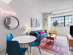 CozySuites Modern 2BR, Downtown Pittsburgh في بيتسبرغ: غرفة معيشة مع أريكة زرقاء وطاولة