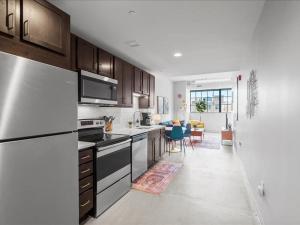 a kitchen with a refrigerator and a stove top oven at CozySuites Modern 2BR, Downtown Pittsburgh in Pittsburgh