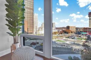 a window with a potted plant and a view of a city at CozySuites Posh 1BR, PPG Paints Arena, Pitts in Pittsburgh