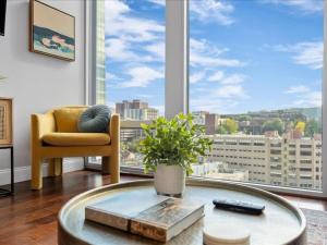 a living room with a table and a large window at CozySuites Roomy 1BR, PPG Paints Arena, Pitts in Pittsburgh