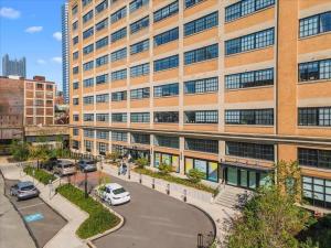 ein großes Gebäude mit Autos auf einem Parkplatz in der Unterkunft CozySuites Trendy 2BR, Downtown Pittsburgh in Pittsburgh