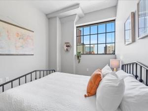 um quarto branco com uma cama com um bicho de peluche laranja em CozySuites Trendy 1BR, Downtown Pittsburgh em Pittsburgh