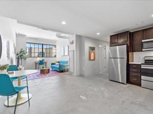 uma cozinha e sala de estar com um frigorífico e uma mesa em CozySuites Trendy 1BR, Downtown Pittsburgh em Pittsburgh