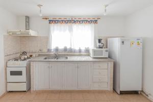 a kitchen with a sink and a refrigerator at Cerro de los Duendes in Santa Rosa de Calamuchita