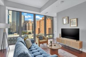 a living room with a blue couch and a large window at CozySuites Spacious 2BR, PPG Paints Arena, Pitts in Pittsburgh