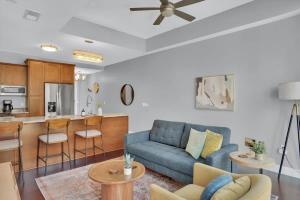 sala de estar con sofá azul y cocina en CozySuites Spacious 2BR, PPG Paints Arena, Pitts en Pittsburgh