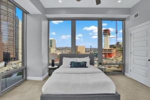 a bedroom with a large bed and a large window at CozySuites Spacious 2BR, PPG Paints Arena, Pitts in Pittsburgh