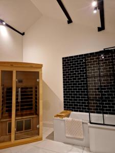 una habitación con una pared de ladrillo negro junto a la aocrin en The Hamilton luxury holiday let's- Holly Barn, en Scorton