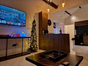 sala de estar con TV y árbol de Navidad en The Hamilton luxury holiday let's- Holly Barn, en Scorton