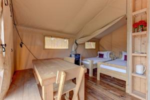 una camera con 2 letti e un tavolo in una tenda di 12 Fires Luxury Glamping with AC #3 a Johnson City