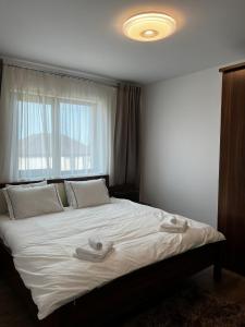 um quarto com uma grande cama branca e uma janela em Chisoda em Chişoda