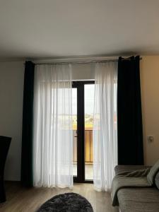 um quarto com uma grande janela com cortinas brancas em Chisoda em Chişoda