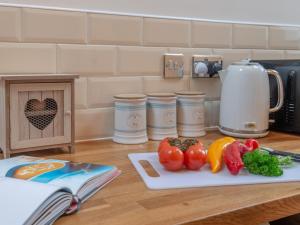 un comptoir de cuisine avec des légumes sur une planche à découper dans l'établissement Brook Cottage - Polar Bears, Alton Towers, Bakewell, Chatsworth House Stay, à Foxt