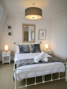 1 dormitorio con 1 cama blanca y 2 lámparas en Spacious 4 Bed Victorian House with Sea Views, en Ilfracombe