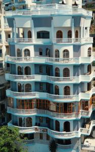 - un bâtiment avec des balcons sur le côté dans l'établissement Monte Cristo Hotel with rooftop pool, à Saranda