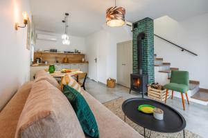a living room with a couch and a fireplace at Domki W Sam Las & SPA Lubenia in Lubenia