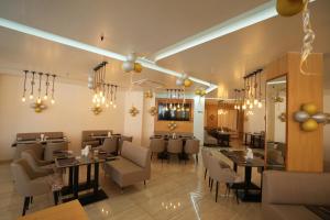 een eetkamer met tafels en stoelen en kroonluchters bij Hotel Raison Inn Bechraji in Kalri
